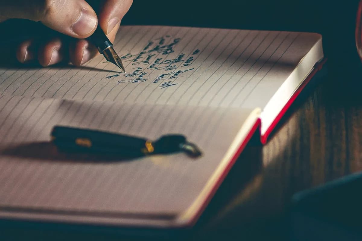 Songwriter reworking a lyric sheet at a piano
